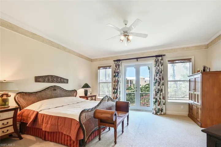 Bedroom with light colored carpet, french doors, ceiling fan, and ornamental molding