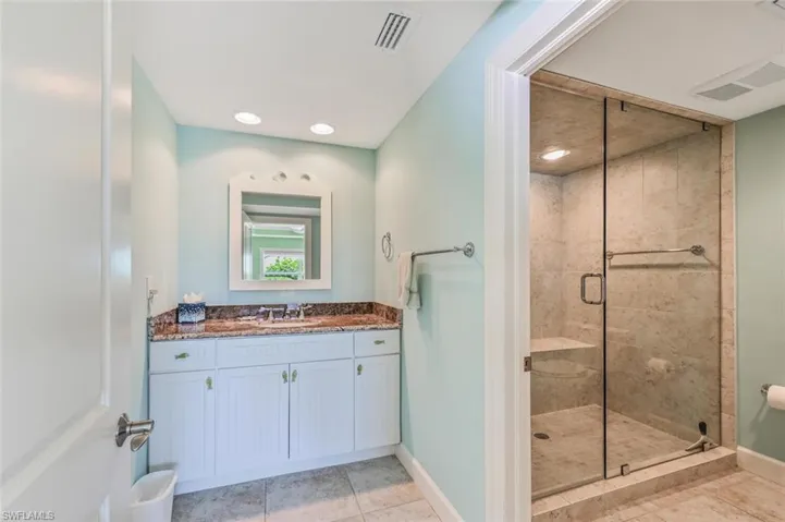 Bathroom with tile patterned floors, vanity, and an enclosed shower
