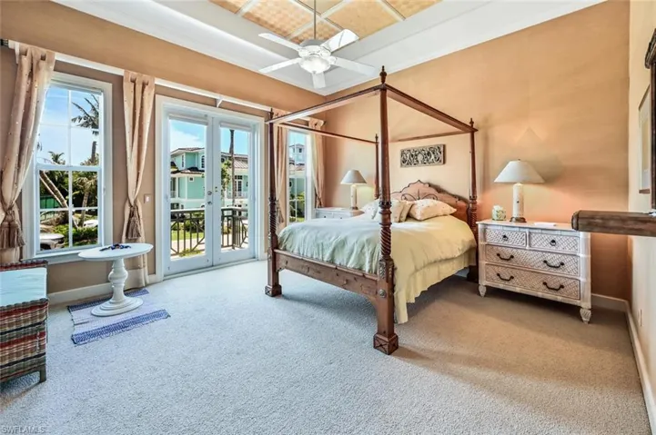 Carpeted bedroom featuring ornamental molding, access to outside, and multiple windows