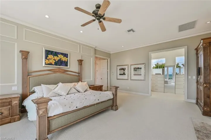Carpeted bedroom with crown molding and ceiling fan