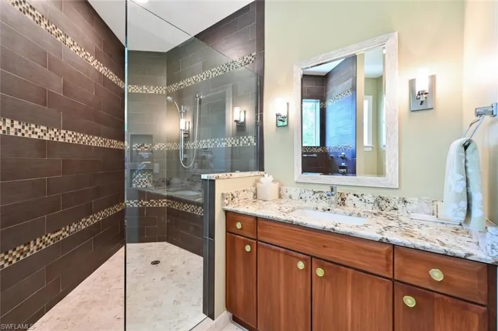 Bathroom with vanity and tiled shower