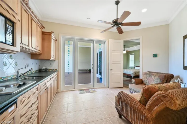 Kitchen with sink, light tile patterned floors, tasteful backsplash, and crown molding