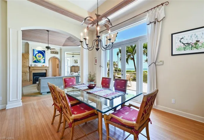 Dining space with ceiling fan with notable chandelier and light hardwood / wood-style floors