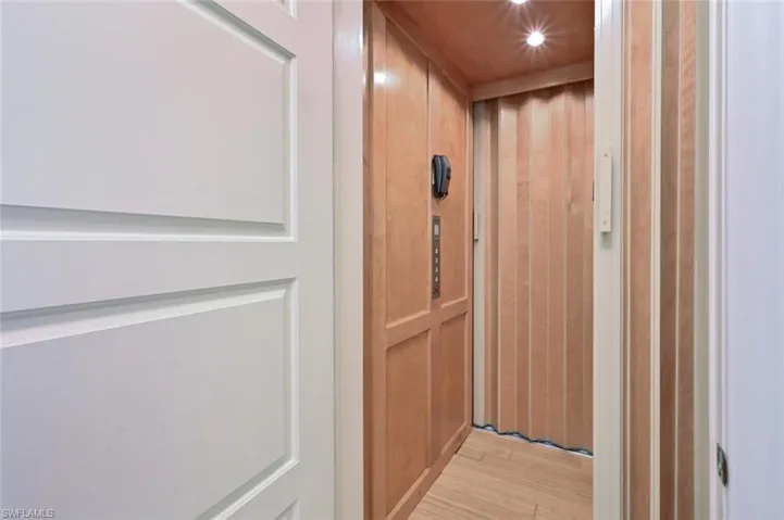 Room details with hardwood / wood-style flooring and elevator