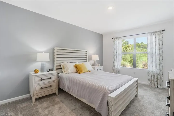 Spacious room featuring carpet flooring, recessed lighting, and a large window with blinds