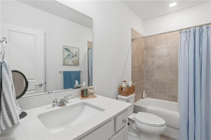 Bathroom featuring a vanity with an integrated sink, chrome faucet, and a large mirror