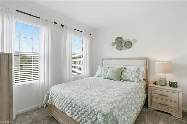 Neutral toned bedroom with light wood-finish bed frame and upholstered headboard