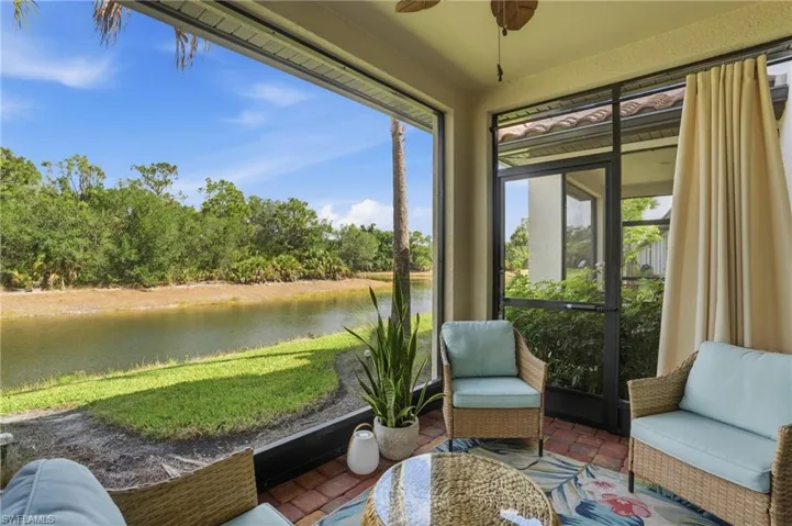Screened patio featuring brick-finish flooring, a ceiling fan, and direct water frontage