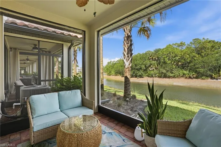 Screened lanai featuring a waterside setting, brick-finish flooring