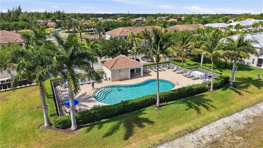 Resort-style pool with integrated steps, surrounded by a paved deck and lounge chairs