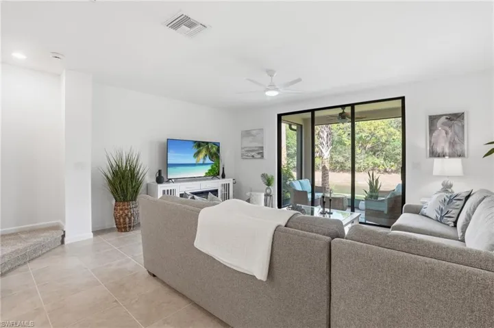 Spacious living area featuring neutral tile flooring and white walls
