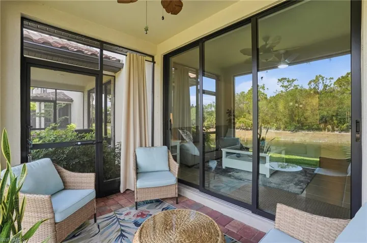 Screened outdoor living space featuring a brick paver patio, impact doors