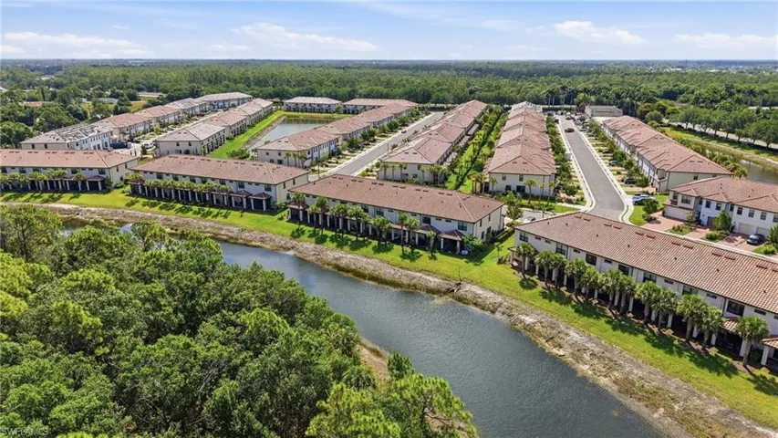 Aerial perspective showcasing a residential community with numerous townhomes featuring terra cotta tile roofs