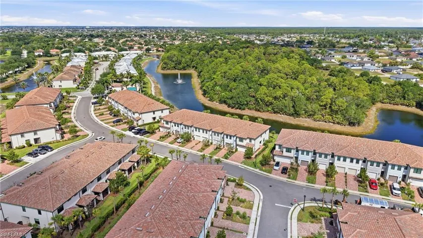Aerial perspective showcasing a residential community with numerous multistory buildings, terra cotta tile roofs, and light-colored facades