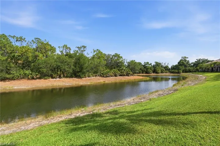 Expansive green lawn bordering a tranquil water feature