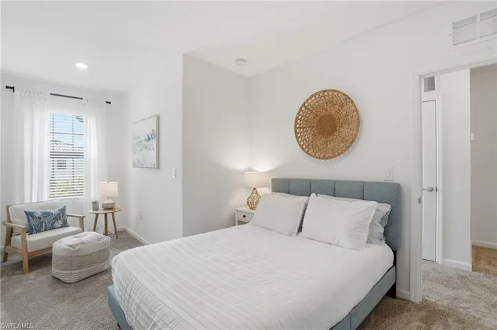 Carpeted bedroom featuring recessed lighting, a window with blinds and sheer curtains, and a white interior door