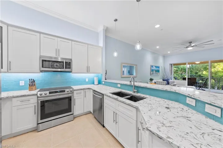 Kitchen featuring appliances with stainless steel finishes, decorative light fixtures, recessed lighting, white cabinets, and a ceiling fan
