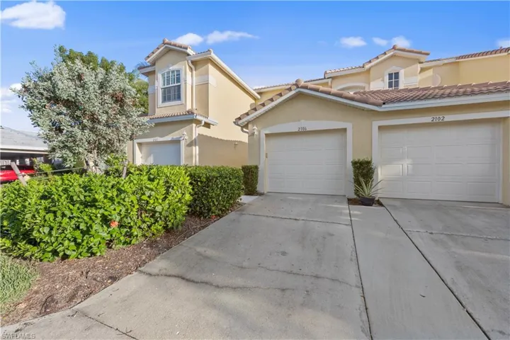 Mediterranean / spanish house with concrete driveway, a tiled roof, stucco siding, and a garage