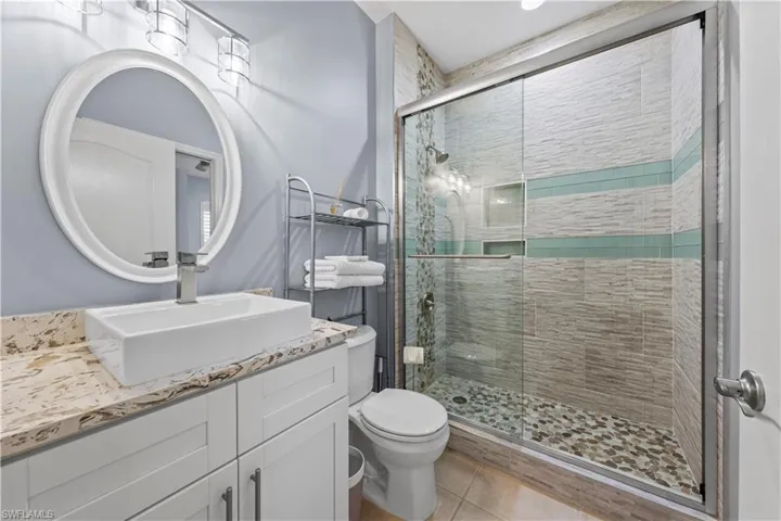 Bedroom with light colored carpet, a ceiling fan, connected bathroom, and recessed lighting