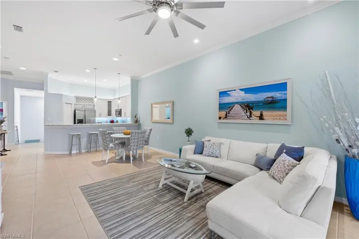 Living area with ornamental molding, light tile patterned flooring, recessed lighting, and ceiling fan