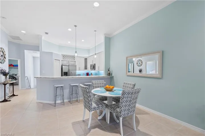 Dining space with light tile patterned flooring, recessed lighting, ornamental molding, and washer / clothes dryer