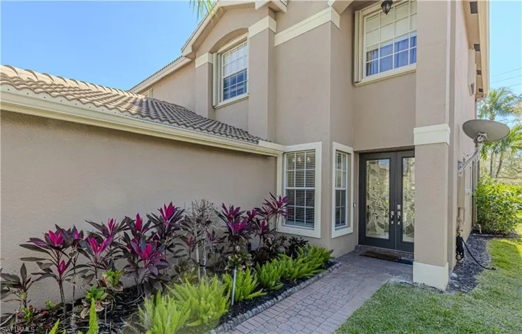 Entrance to property with stucco siding, a tiled roof, and french doors