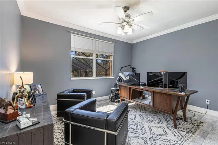 Office with baseboards, ceiling fan, ornamental molding, and wood finished floors