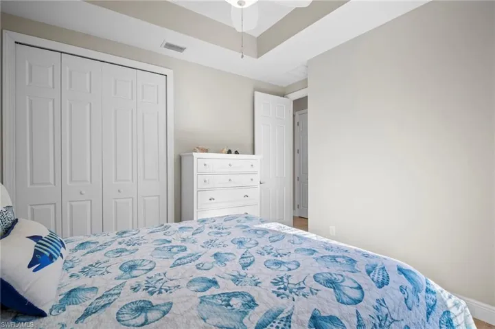 Bedroom featuring ceiling fan, a closet, and a raised ceiling