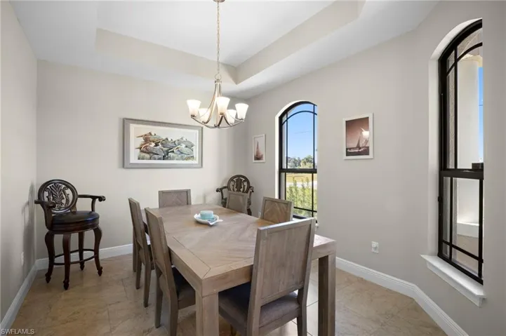Dining space featuring a raised ceiling and a chandelier