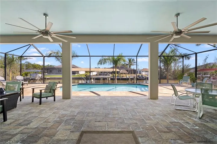 Swimming pool with a patio, a lanai, a sunroom, and a water view