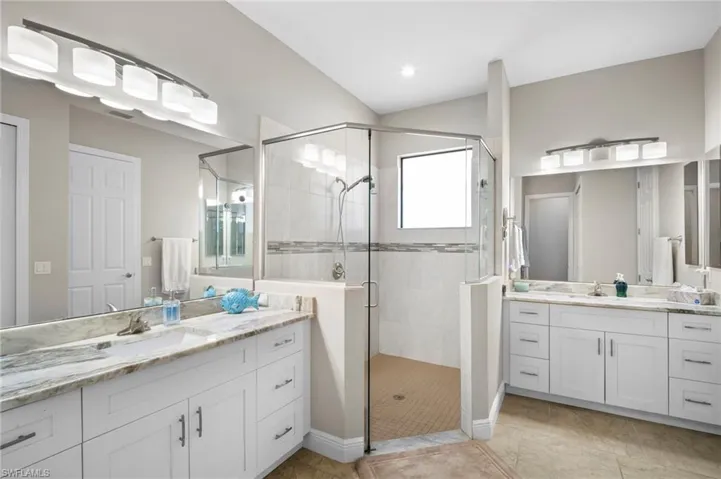 Full bathroom with two vanities and a shower stall