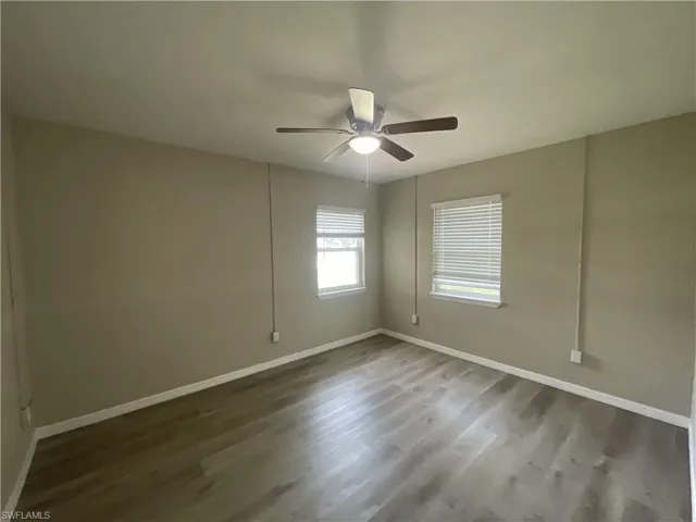 Bedroom with dark wood-type flooring and a ceiling fan