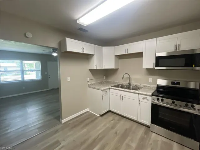 Kitchen featuring stainless steel appliances, and white cabinetry,