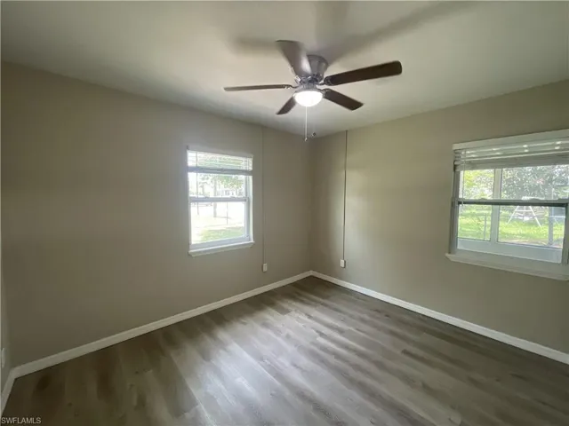 Bedroom with dark wood-type flooring and a ceiling fan