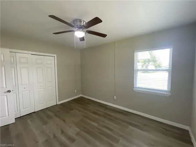 Unfurnished bedroom featuring wood finished floors, a closet, and a ceiling fan
