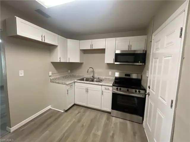 Kitchen with appliances with stainless steel finishes, and white cabinets