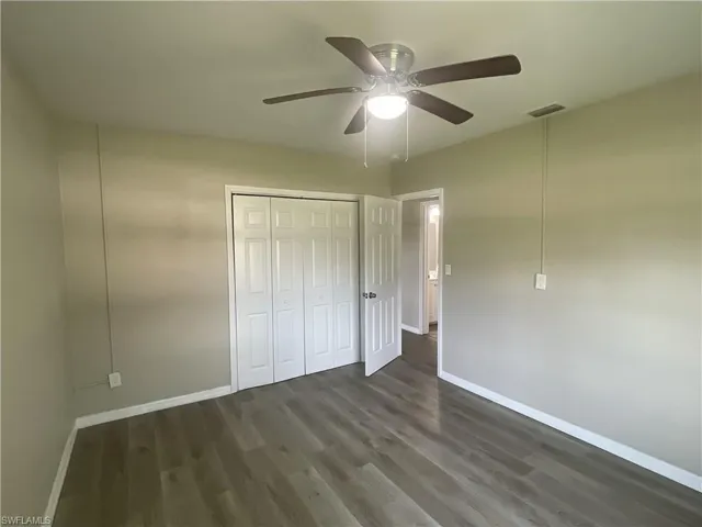 Unfurnished bedroom a closet, and a ceiling fan