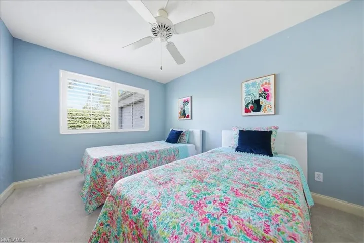 Carpeted bedroom featuring baseboards and ceiling fan
