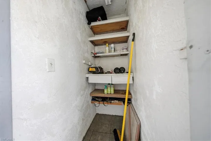 Stairway with tile patterned floors and a textured wall