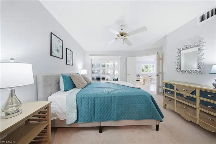 Carpeted bedroom featuring ceiling fan