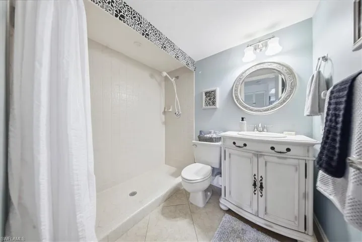 Bathroom featuring vanity, a stall shower, and light tile patterned floors