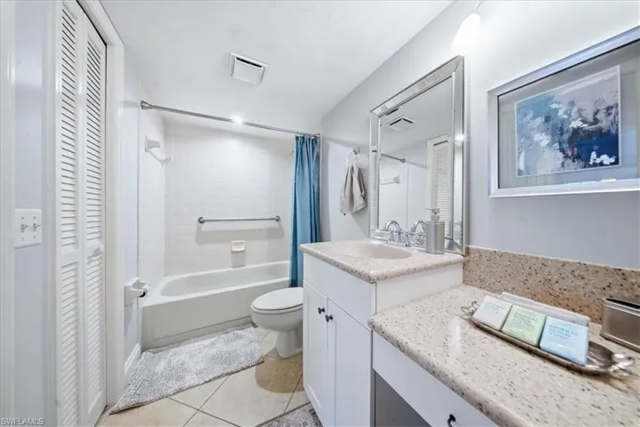 Full bath with a closet, vanity, shower / tub combo, and light tile patterned floors