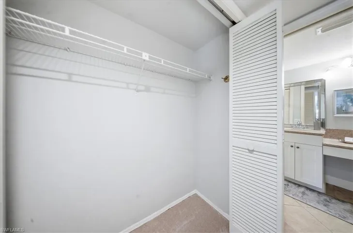 Spacious closet featuring light carpet and light tile patterned flooring