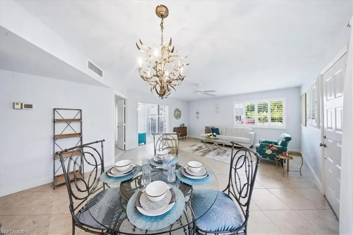 Dining space featuring a chandelier, light tile patterned floors, and ceiling fan