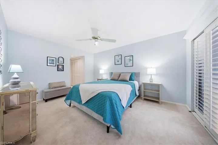 Carpeted bedroom featuring a closet and a ceiling fan