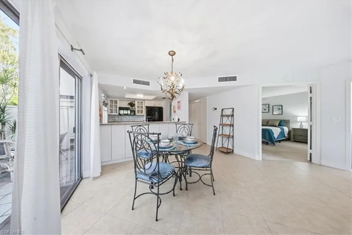 Dining area with a chandelier, light tile patterned flooring, and vaulted ceiling