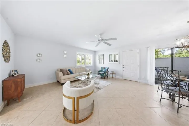 Living area featuring light tile patterned floors and a ceiling fan