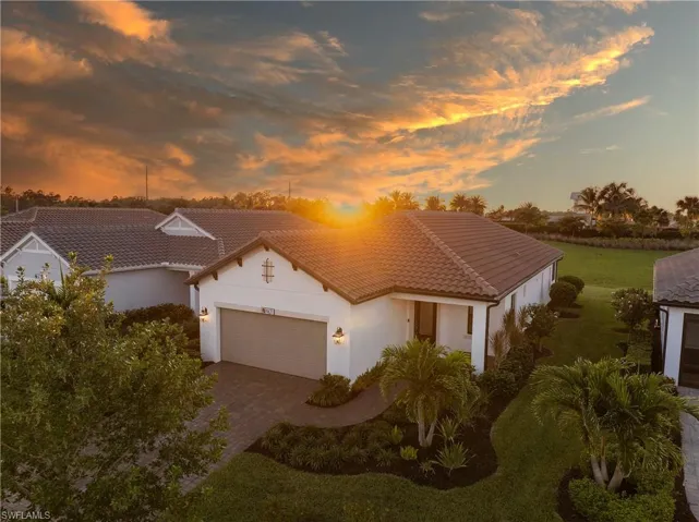 Mediterranean / spanish-style home with stucco siding, a tiled roof, an attached garage, and decorative driveway