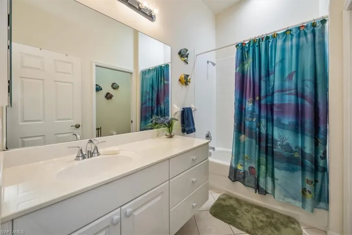 Bathroom featuring vanity, tile patterned floors, and shower / bath combination with curtain