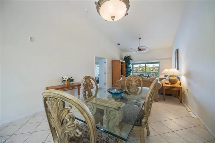 Tiled dining area featuring high vaulted ceiling and ceiling fan